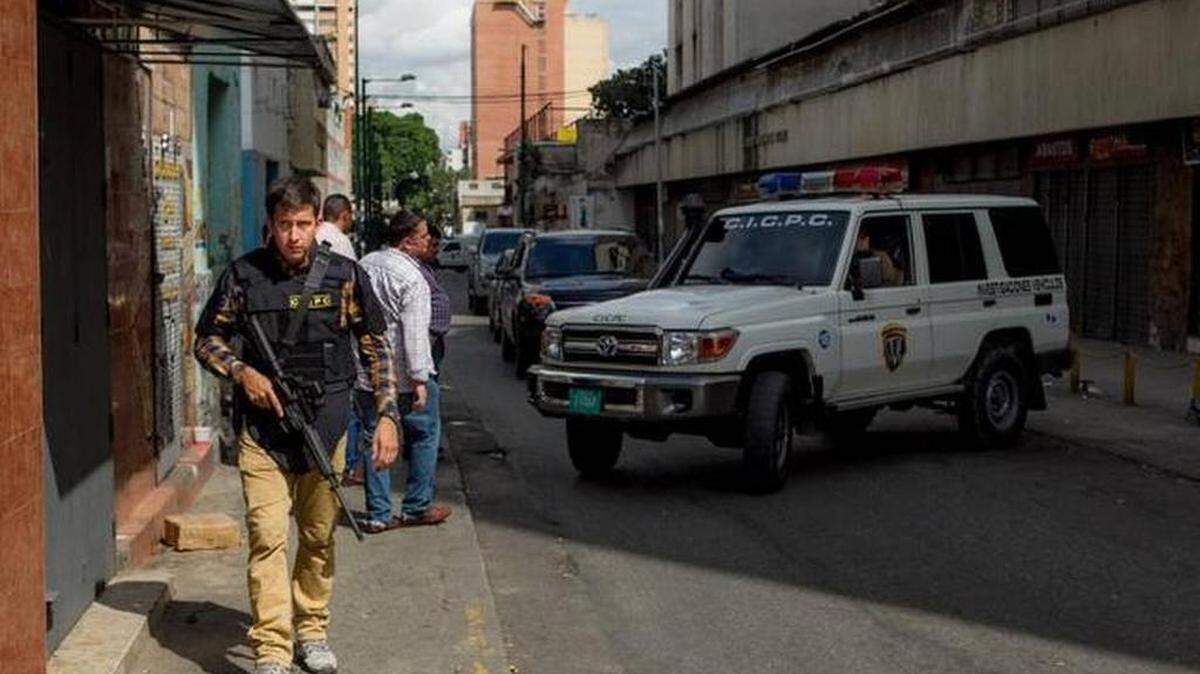 Miembros del Cuerpo de Investigaciones Científicas, Penales y Criminalísticas (CICPC), aguardan en las inmediaciones del edificio Manfredir donde hubo enfrentamientos con supuestos delincuentes el martes 7 de octubre del 2014, en Caracas (Venezuela).