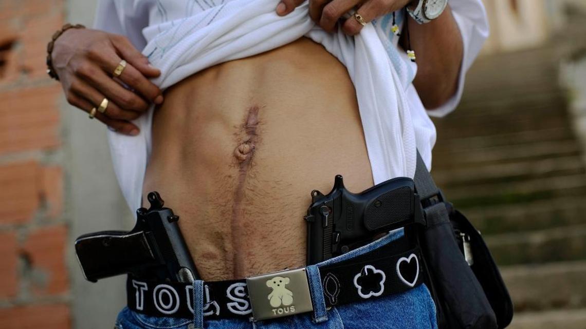 Un narcotraficante identificado como “El Patán” muestra su arma y una cicatriz en el vientre en un vecindario de Caracas en noviembre del 2007.