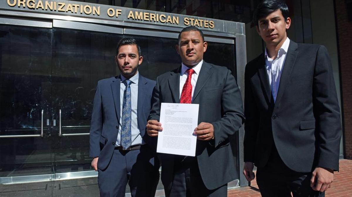 
El coordinador mundial de los Estudiantes de Venezuela en el Exterior (EVE), Carlos Moreno, junto al coordinador para Boston Diego Rojo (d) y el de Washington, DC Santiago Falconi (i) muestran el documento que fue entregado al Dr. Christopher Hernández, Director del Departamento para la Cooperación y Observación Electoral de la OEA, en la capital estadounidense. 

