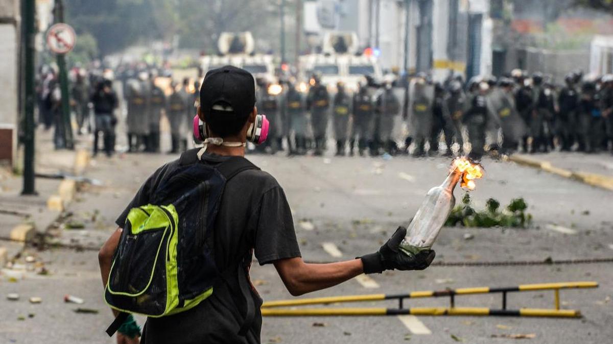 Un activista de la oposición venezolana sostiene un cóctel Molotov encendido durante los enfrentamientos con la policía antidisturbios en Caracas el 10 de abril de 2017.