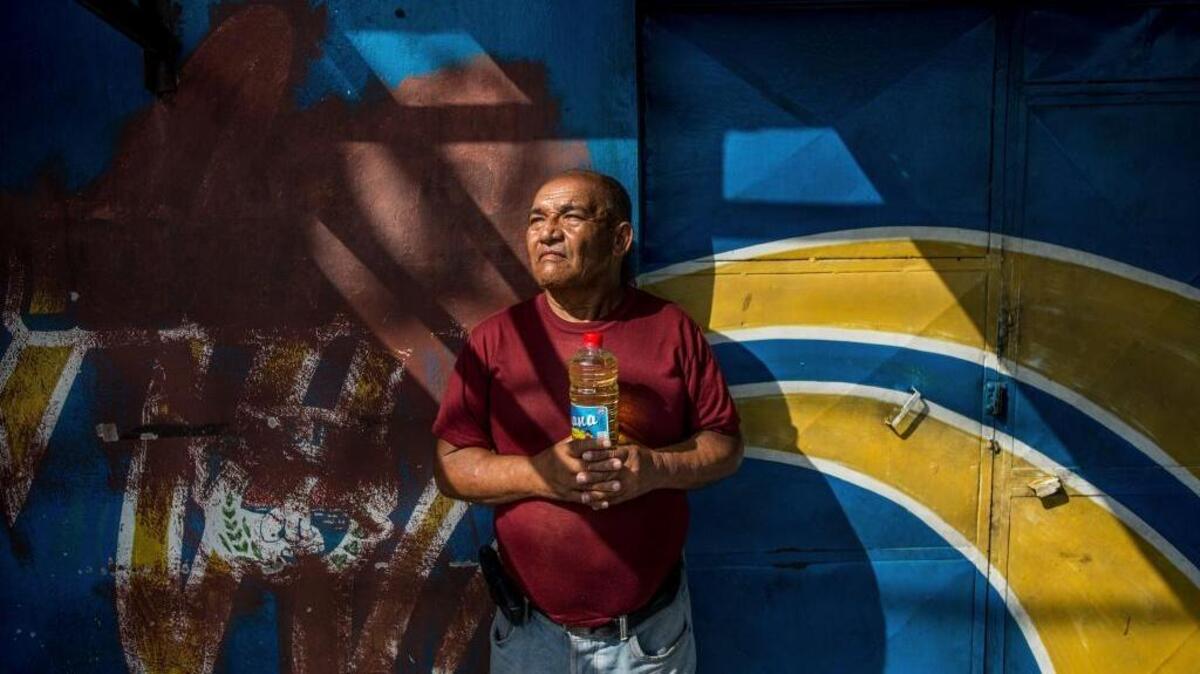 Después de esperar en una larga fila en un mercado, José Francisco Molina Sierra solo pudo comprar dos botellas de aceite para cocinar, en Puerto Cabello, Venezuela, el 27 de enero.