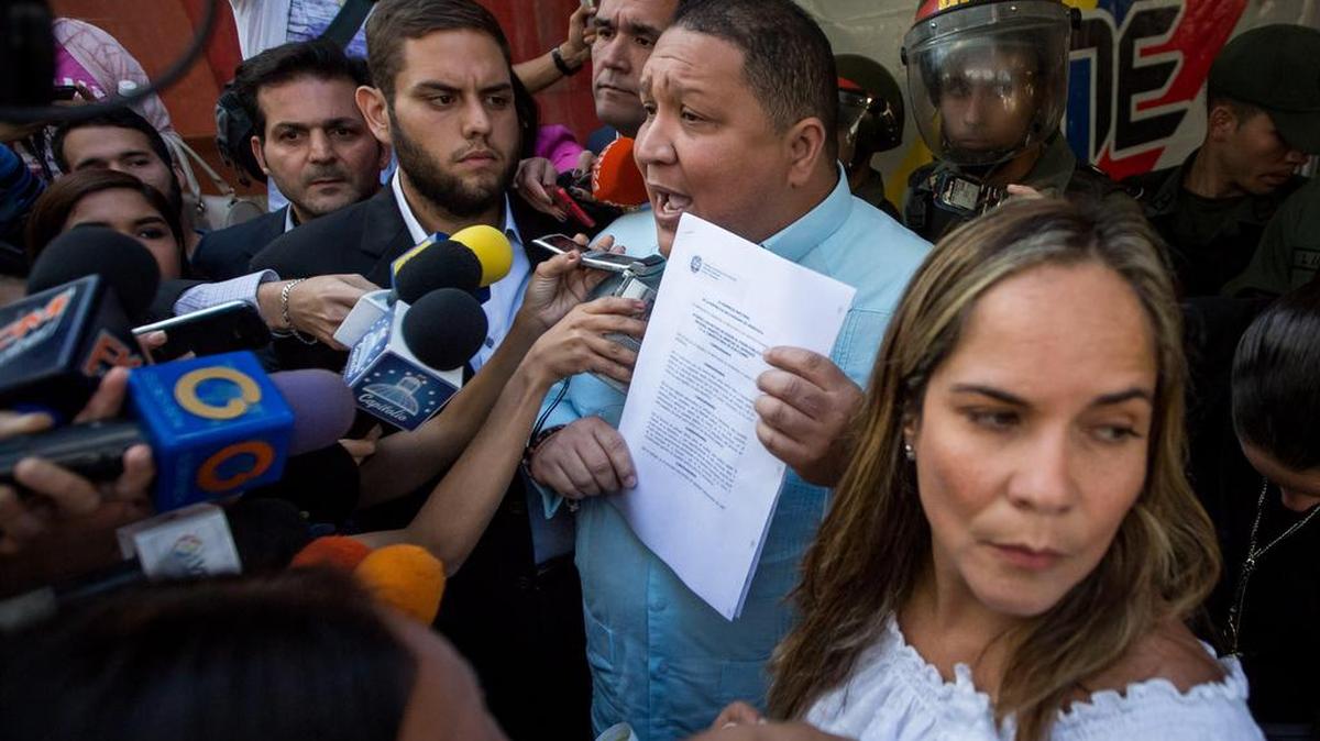 Los diputados de la coalición opositora Mesa de la Unidad Democrática (MUD) José Brito (c) y Juan Requesens (i) permanecen a la entrada del Consejo Nacional Electoral (CNE) que es custodiado por miembros de la Guardia Nacional Bolivariana (GNB) el 2 de febrero de 2017, en la ciudad de Caracas (Venezuela).