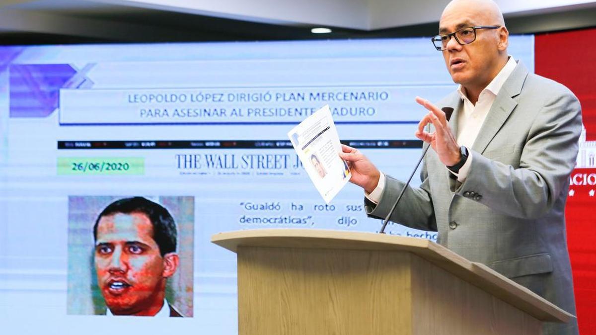 La Presidencia venezolana muestra al Ministro de Comunicaciones de Venezuela, Jorge Rodríguez, hablando durante un anuncio televisado en el que el gobierno acusó al político venezolano de oposición Leopoldo López de planear una incursión armada en el país, mientras se muestra en la pantalla una imagen del líder opositor Juan Guaido, en el Palacio Presidencial de Miraflores en Caracas el 27 de junio de 2020.