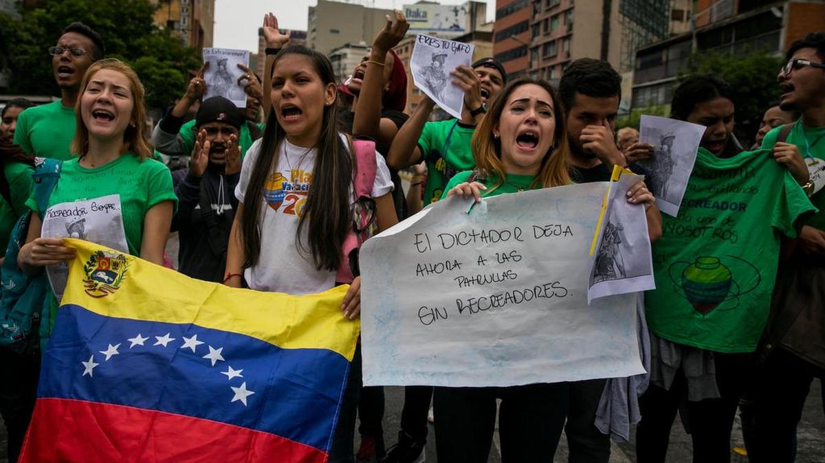 Venezolanos protestan mientras Trabajadores del Ministerio Público realizan el jueves 8 de junio de 2017, el levantamiento planimétrico en el lugar en el que un joven de 17 años murió durante una protesta opositora, en Caracas (Venezuela).