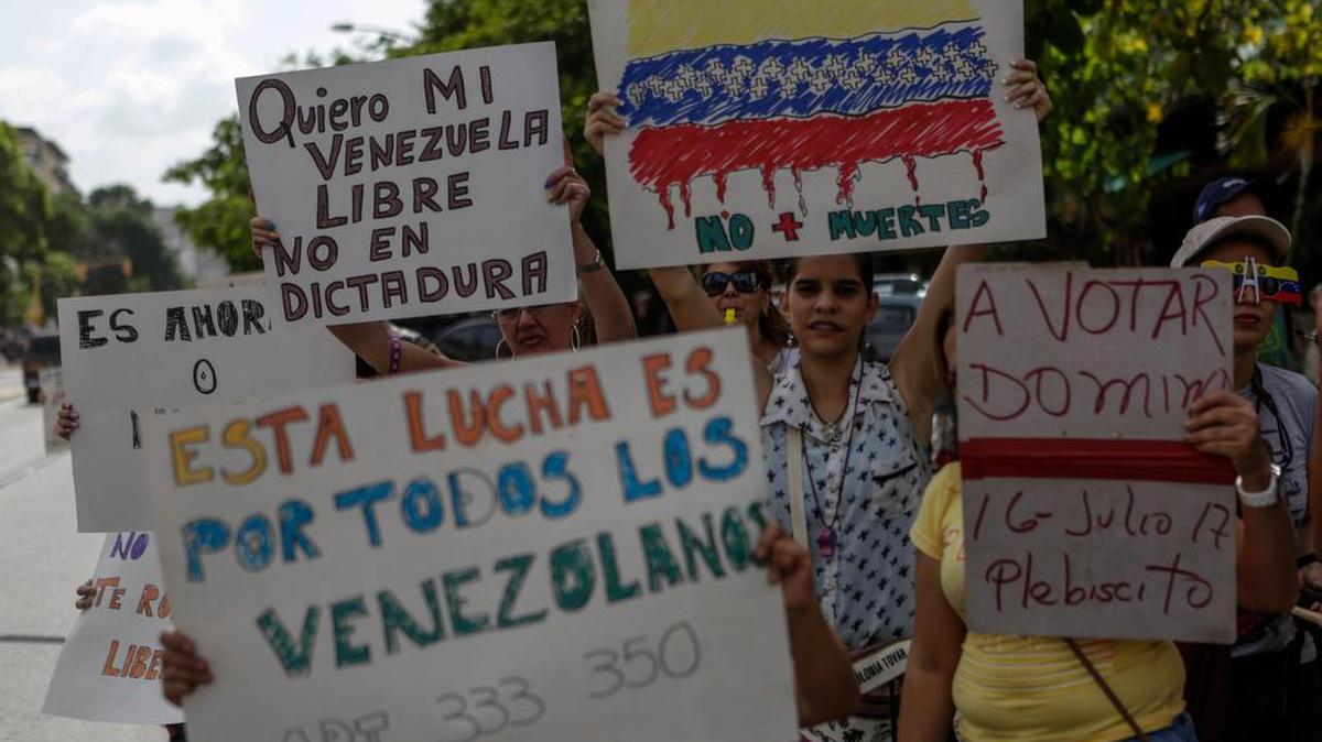 Simpatizantes de la oposición muestran carteles mientras bloquean una calle durante el “trancazo” del lunes 10 de julio de 2017, en Caracas, Venezuela.