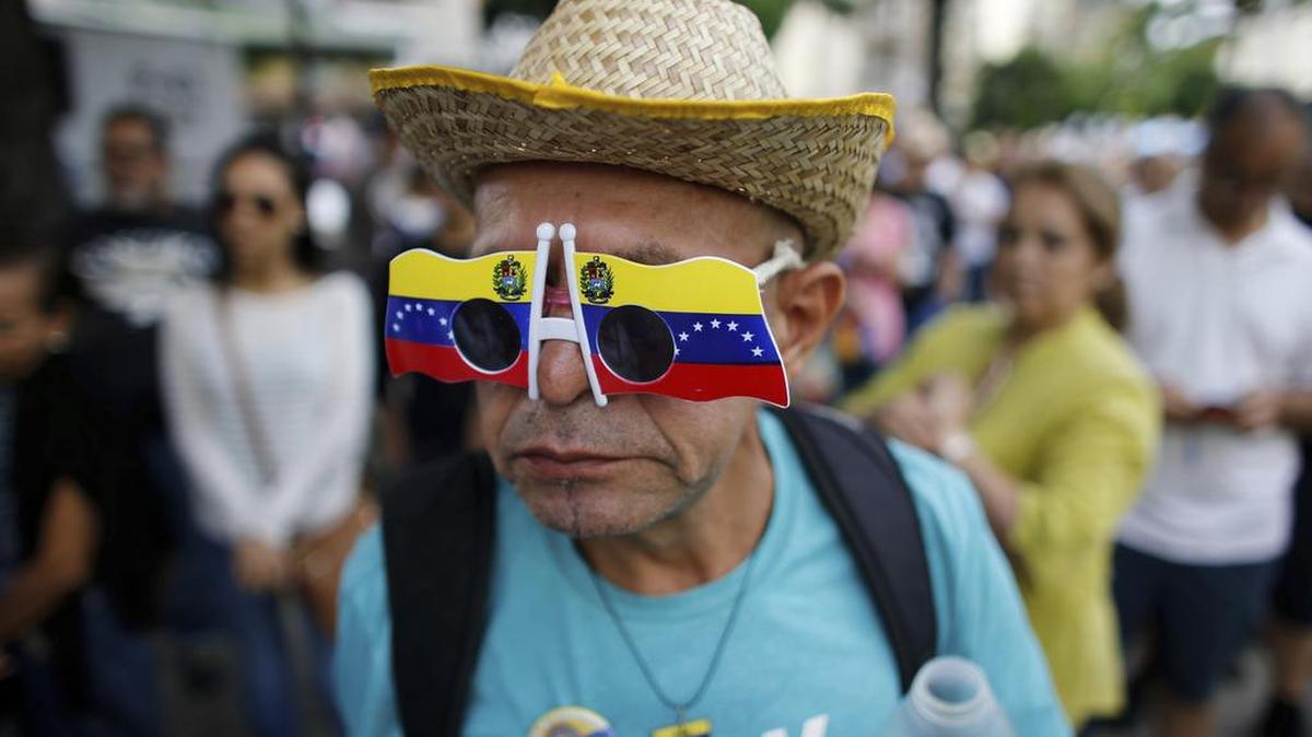 Un hombre con gafas con los colores de la bandera venezolana antes de votar en una estación de votación durante un referéndum simbólico en Caracas, Venezuela, el domingo 16 de julio de 2017.