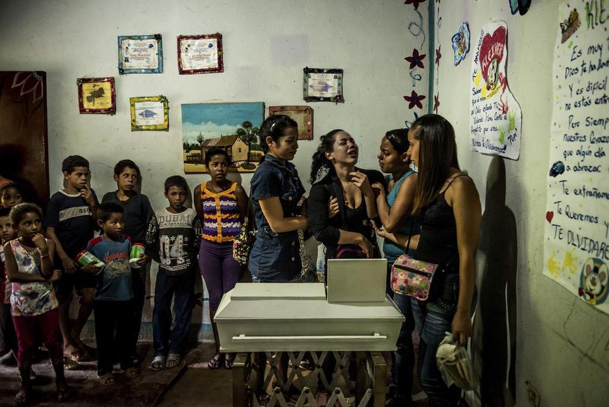 Kelly Hernández llora junto con sus familiares durante el velorio para su hijo Kleiver, de 3 meses, en agosto, en la población de Urdaneta, Venezuela.