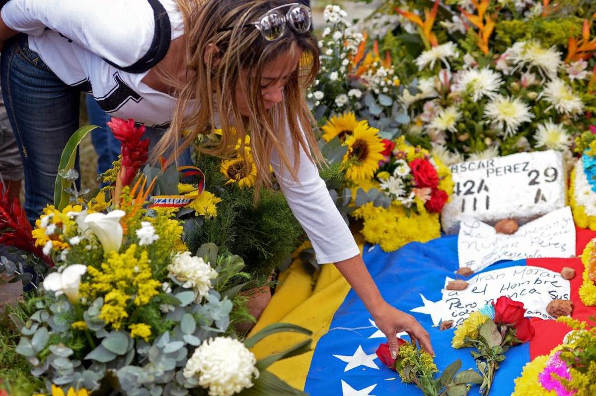 Una mujer deposita flores en la tumba del policía Óscar Pérez en Caracas, el 21 de enero de 2018.