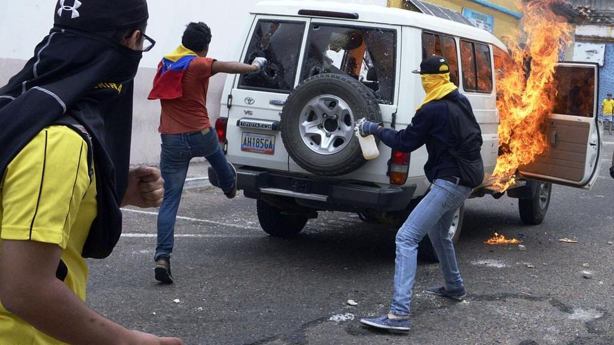 Estudiantes incendian un vehículo de Petróleos de Venezuela durante una protesta el jueves en San Cristobal, Venezuela.