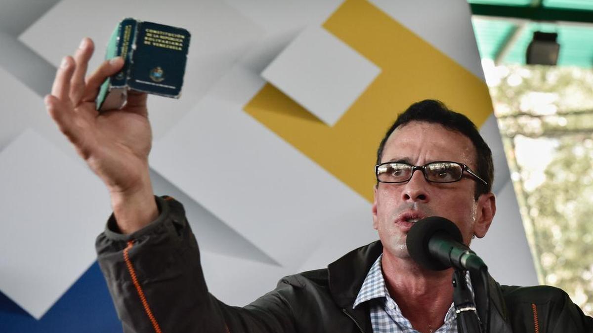 Henrique Capriles, líder de la oposición y candidato presidencial en dos ocasiones, muestra una copia de la Constitución de Venezuela, durante una conferencia de prensa en Caracas, Venezuela, el miércoles, 17 de febrero de 2016.
