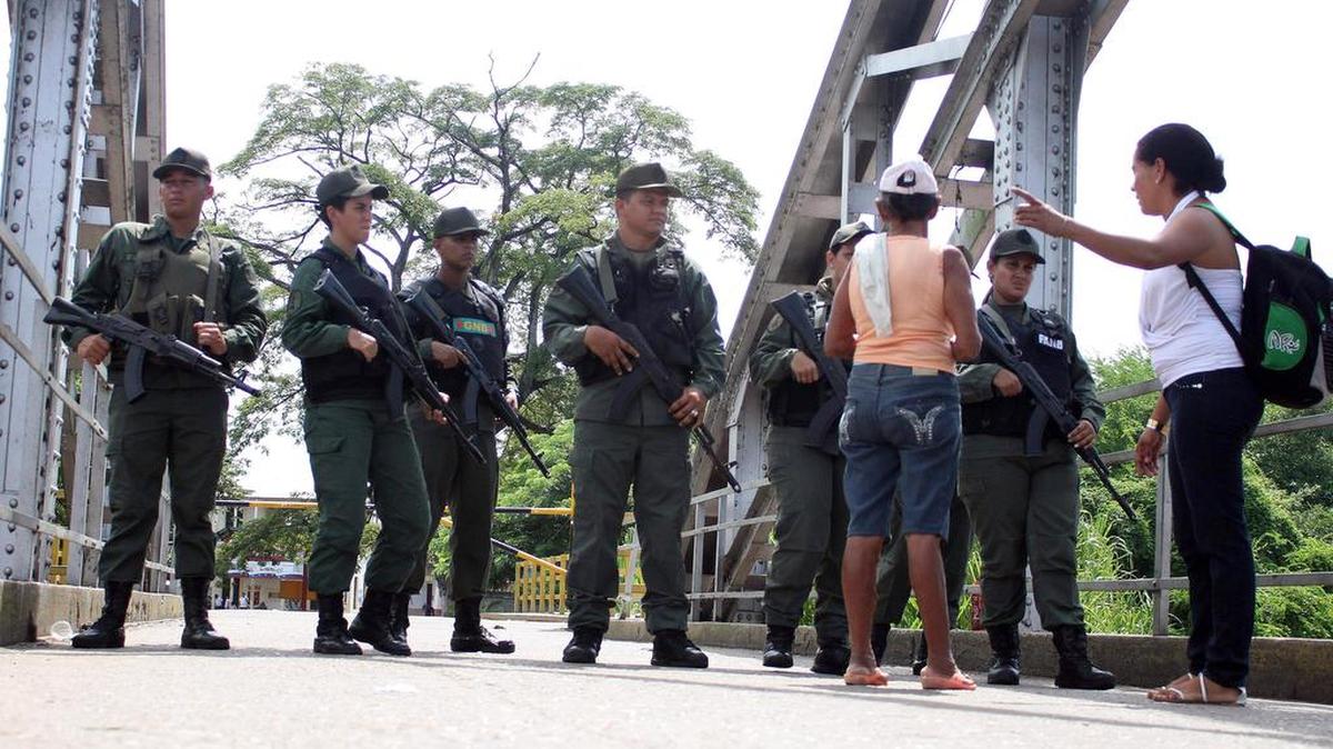 
 Ciudadanos colombianos hablan con guardias venezolanos en el Puente La Unión buscando pasar la frontera el sábado 29 de agosto de 2015, en Puerto Santander (Colombia). 
