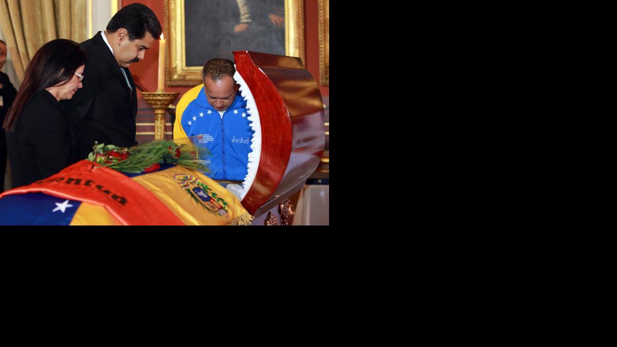 
El presidente venezolano Nicolás Maduro (cent.), la primera dama Cilia Flores y el presidente de la Asamblea Nacional Diosdado Cabello frente al cadáver del diputado Robert Serra, quien fue asesinado por sicarios, en Caracas, Venezuela.
