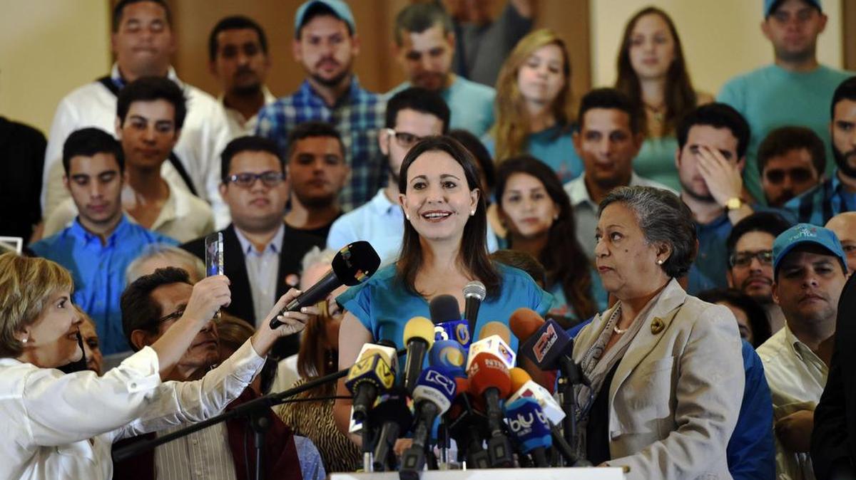 
La dirigente de la oposición María Corina Machado (centro) da una conferencia de prensa el jueves 6 de agosto de 2015, en Caracas, Venezuela. Machado criticó la decisión de la MUD de excluir como candidata a Isabel Pereira, quien fue escogida por Machado para sustituirla en las elecciones parlamentarias. 
