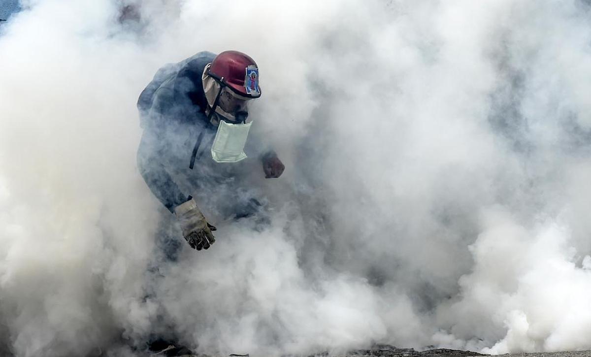 Gases lacrimógenos cubren a un manifestante opositor el jueves en Caracas, Venezuela.