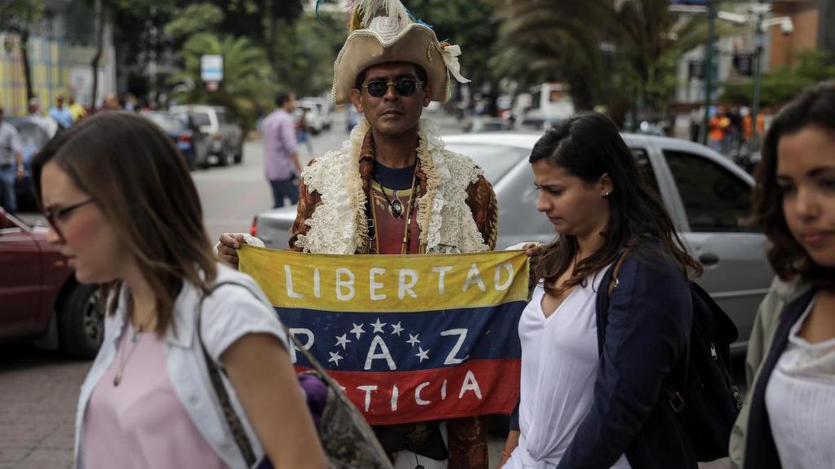 Un manifestante sostiene una bandera cerca de donde se realiza una sesión de la Asamblea Nacional de Venezuela el viernes 21 de julio de 2017, en Caracas (Venezuela).