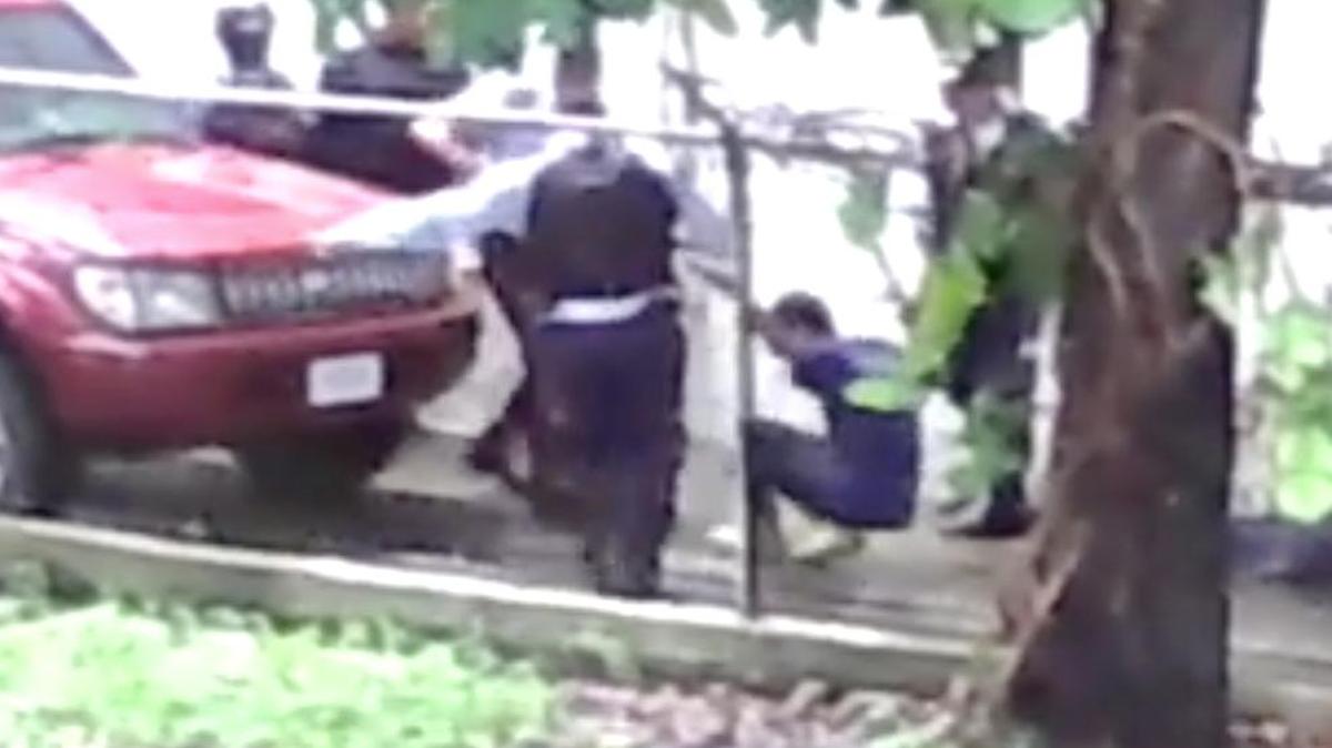 
Imagen tomada de un video que muestra el momento en que el presunto delincuente se desploma tras recibir un balazo mientras era sujetado por dos agentes de la policía en el estado Aragua, en Venezuela.
