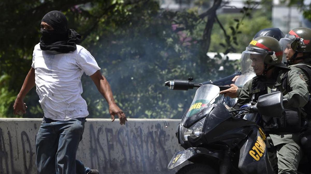 Un manifestante de la oposición es perseguido por motociclistas de la Guardia Nacional durante una manifestación contra el gobierno en Caracas, el 20 de julio de 2017.