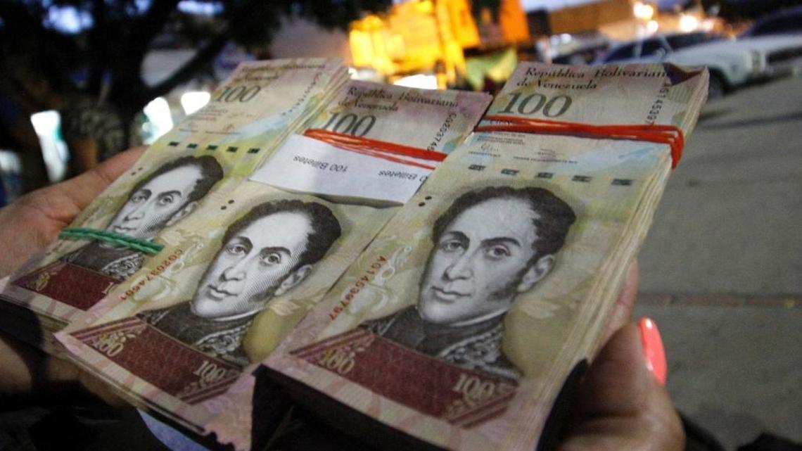 Una mujer muestra billetes de 100 bolívares en La Parada, en el Municipio Villa del Rosario, Departamento colombiano de Norte de Santander, el 11 de diciembre.