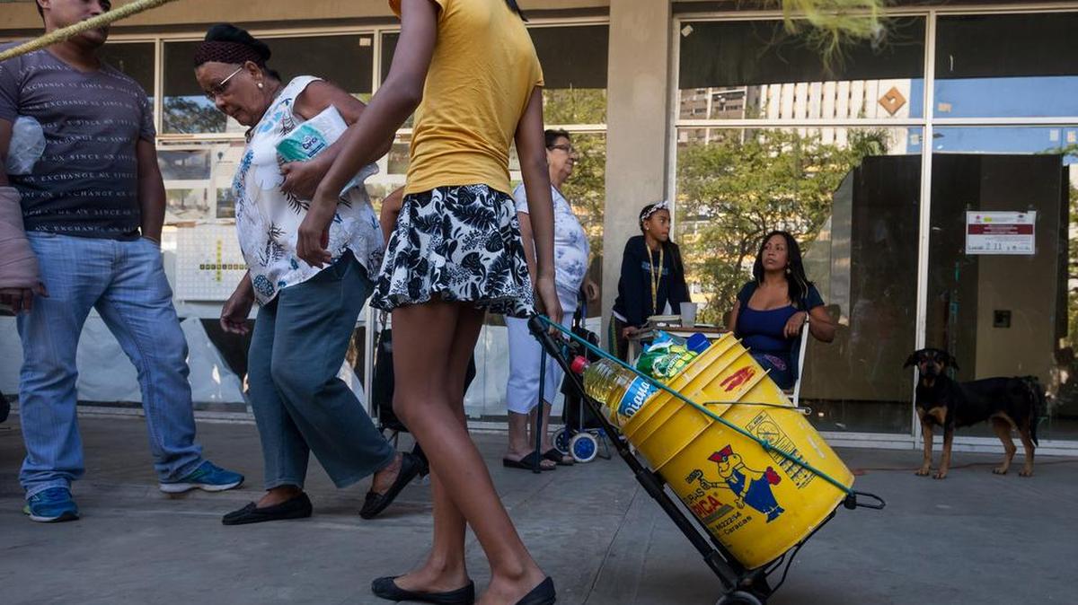 Un grupo de personas hacen fila para comprar una bolsa con alimentos en una venta realizada en un edificio del plan habitacional gubernamental "Misión Vivienda" el sábado 23 de enero de 2016, en la ciudad de Caracas (Venezuela).