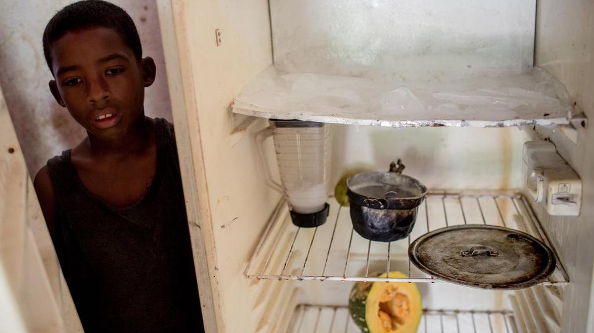 Joffren Polanco muestra su refrigerador vacío en Caracas.