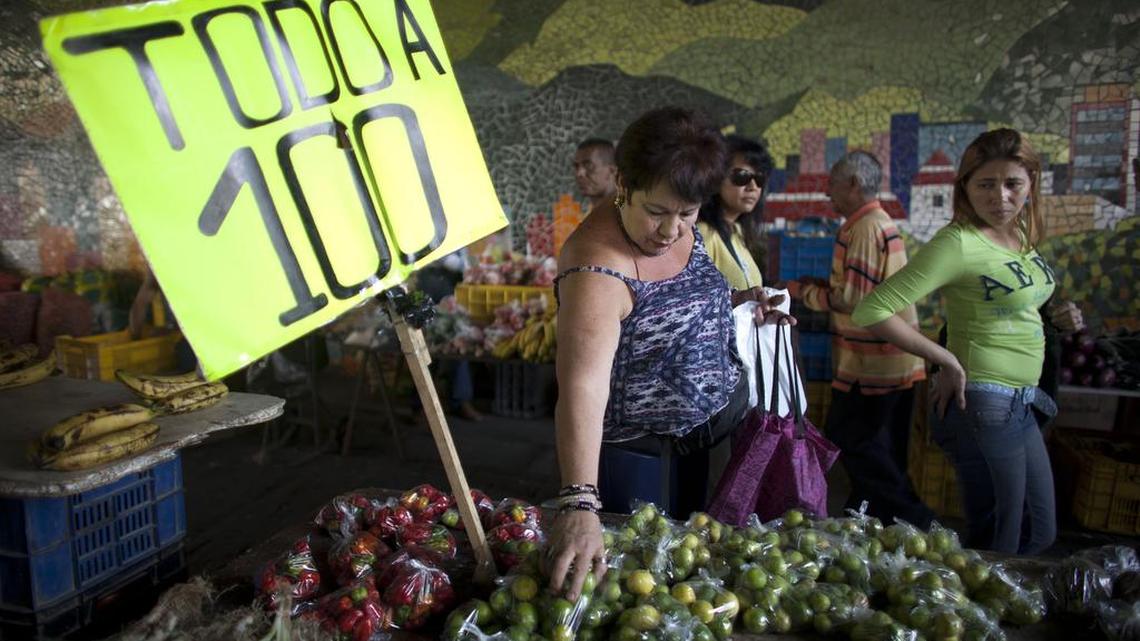 Varias personas compran vegetales en un mercado callejero de Caracas, el viernes 19 de febrero. Afirman los analistas que “las medidas anunciadas no hacen nada para cubrir el déficit de divisas”.