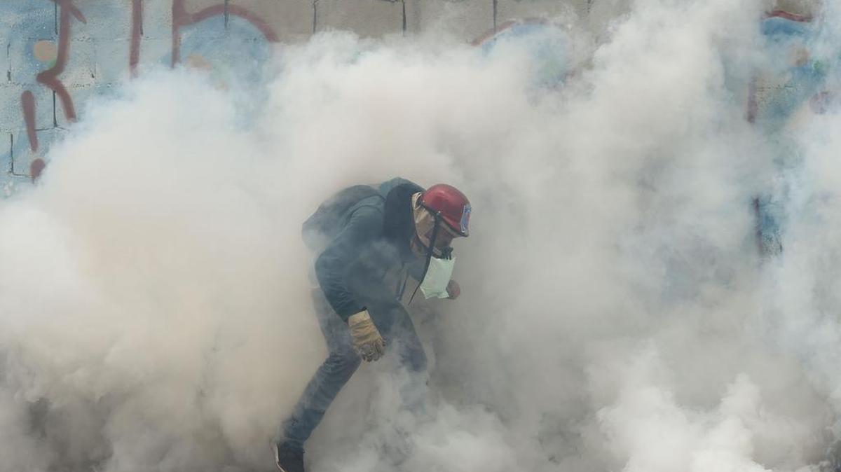 Gases lacrimógenos cubren a un manifestante opositor este jueves 20 de abril de 2017 en Caracas, Venezuela.