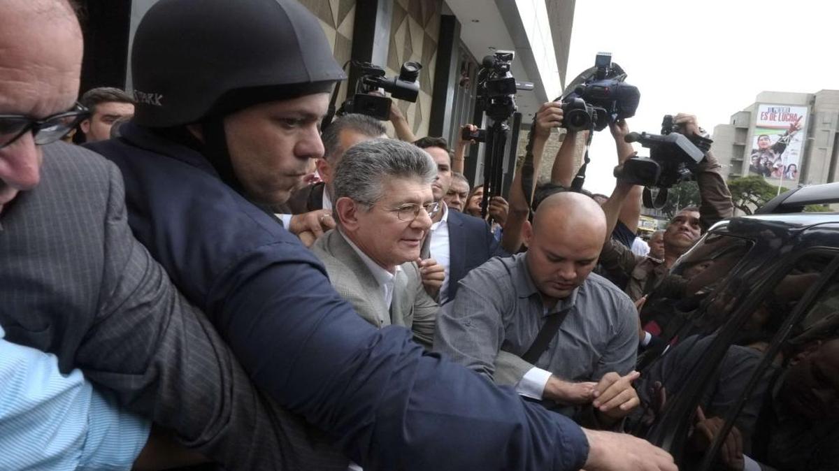 El diputado opositor Henry Ramos Allup (centro), quien asumirá la presidencia de la Asamblea Nacional de Venezuela, intenta volver a su auto después de que le impidieran el ingreso a las instalaciones parlamentarias.