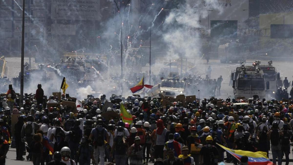 Miles de manifestantes son dispersados con gas lacrimógeno por fuerzas de seguridad, el jueves en Caracas, Venezuela.