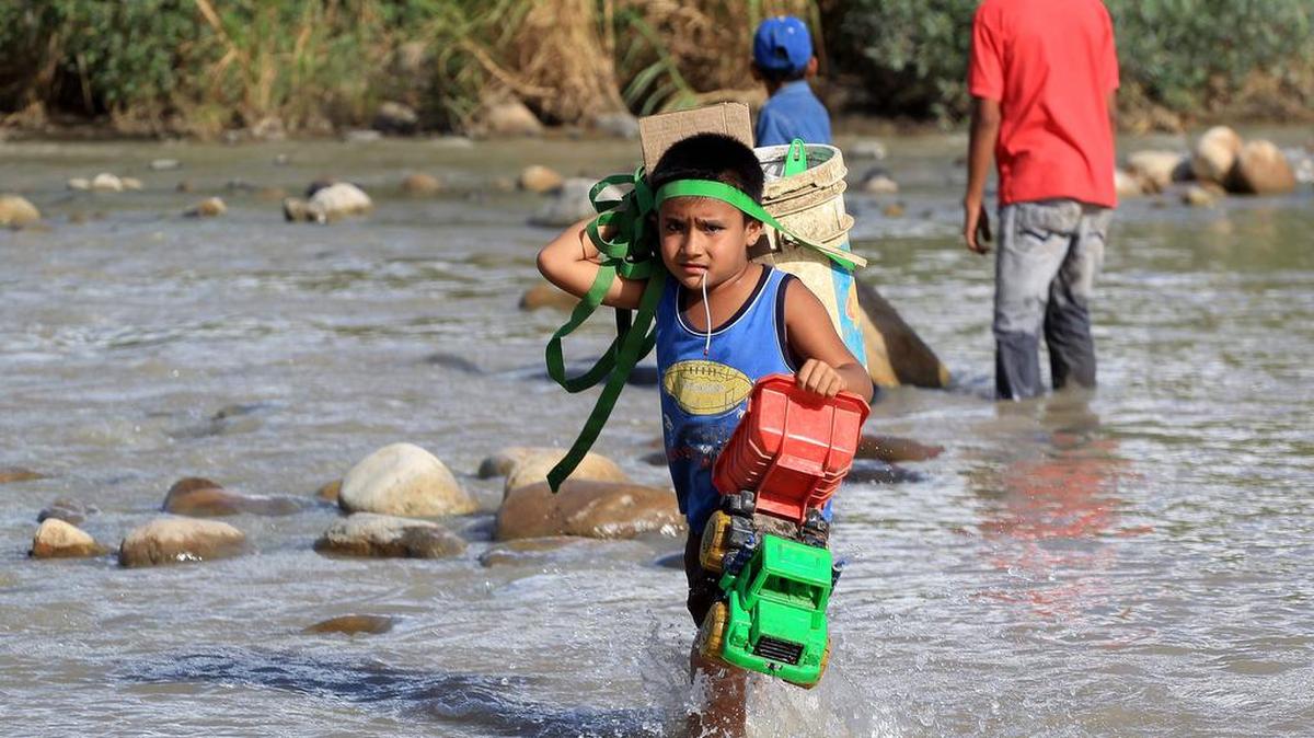 
Colombianos cargan sus pertenencias por el río Táchira desde Venezuela hacia el sector La Parada (Colombia) EL martes 25 de agosto de 2015, en Cúcuta, Colombia. 
