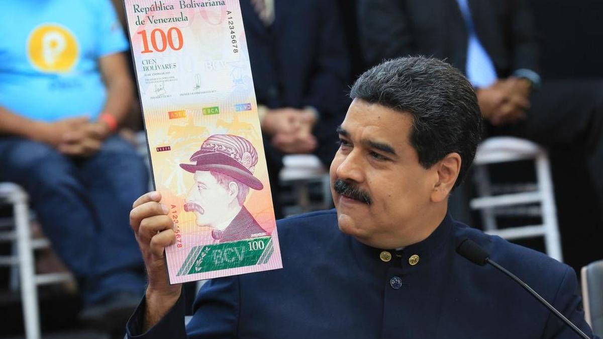 Fotografía cedida por prensa de Miraflores donde se observa al presidente venezolano, Nicolás Maduro, quien muestra una imagen de un billete el jueves 22 de marzo de 2018, en Caracas. Maduro ordenó la eliminación de tres ceros del bolívar y sacar de circulación el cono monetario vigente a partir del próximo 4 de junio.