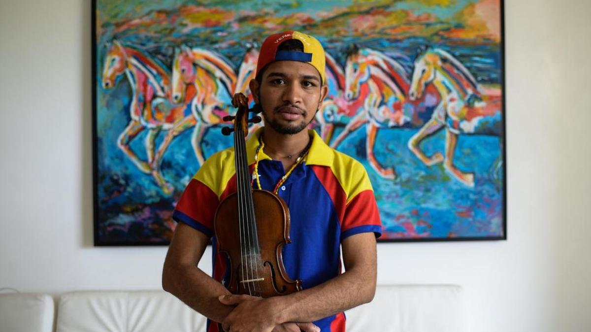 El activista de la oposición Wuilly Arteaga, posa con su violín durante una entrevista con la AFP en Caracas el 1 de septiembre de 2017.