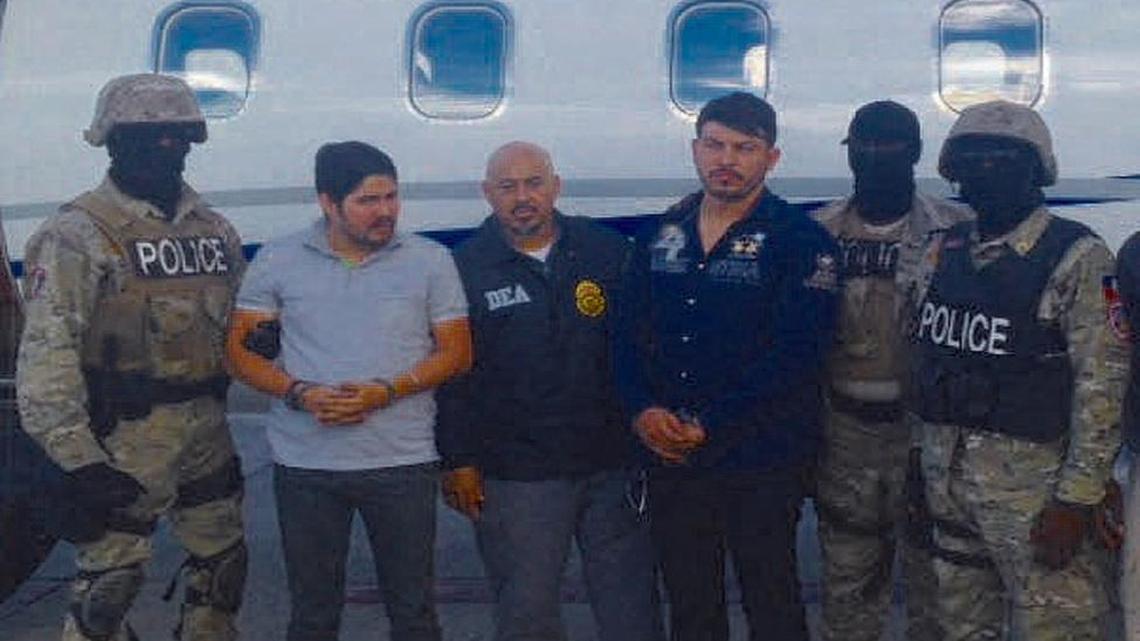 Efraín A. Campo, segundo de la izquierda y FRanki F. Flores, cuarto desde la izquierda, esposados después del arresto en Haití.