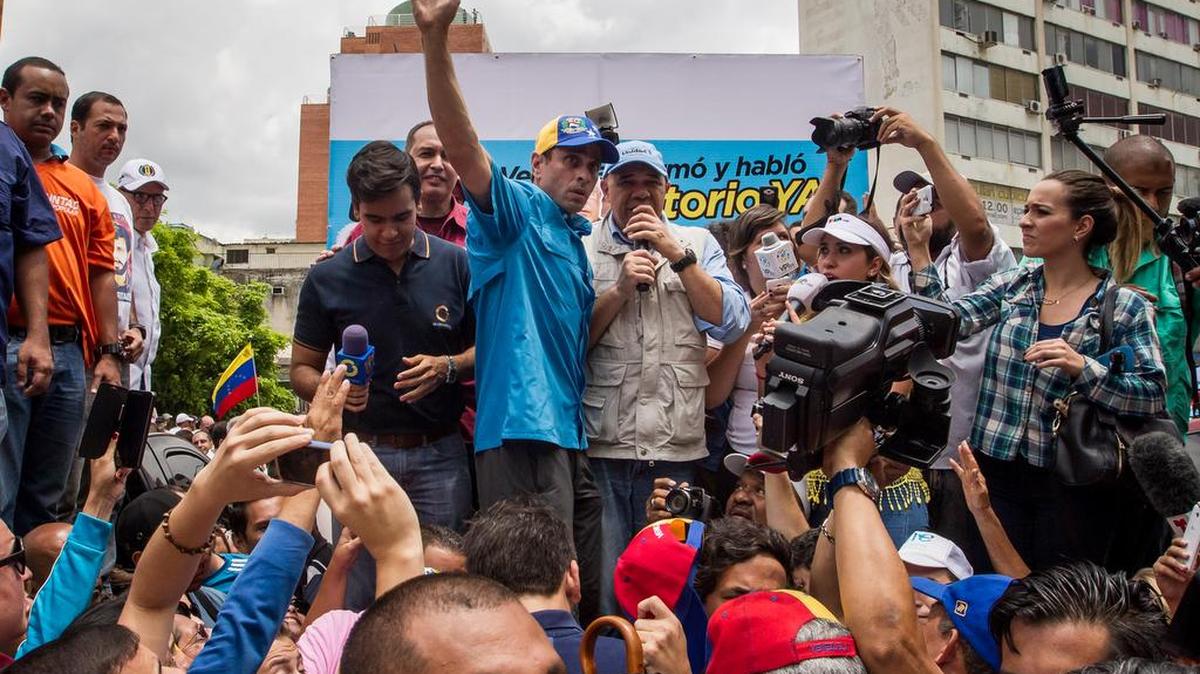 El líder opositor venezolano y ex candidato presidencial Henrique Capriles (c), acompañado del secretario general de la coalición opositora Mesa de Unidad Democrática (MUD), Jesus Torrealba (c-d), participan en una protesta contra el Gobierno venezolano el sábado 14 de mayo del 2016, en Caracas (Venezuela).