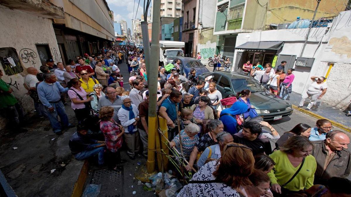 Un grupo de personas hace fila a las afueras de un supermercado en Caracas el 22 de enero del 2016, con la esperanza de poder comprar papel higiénico.