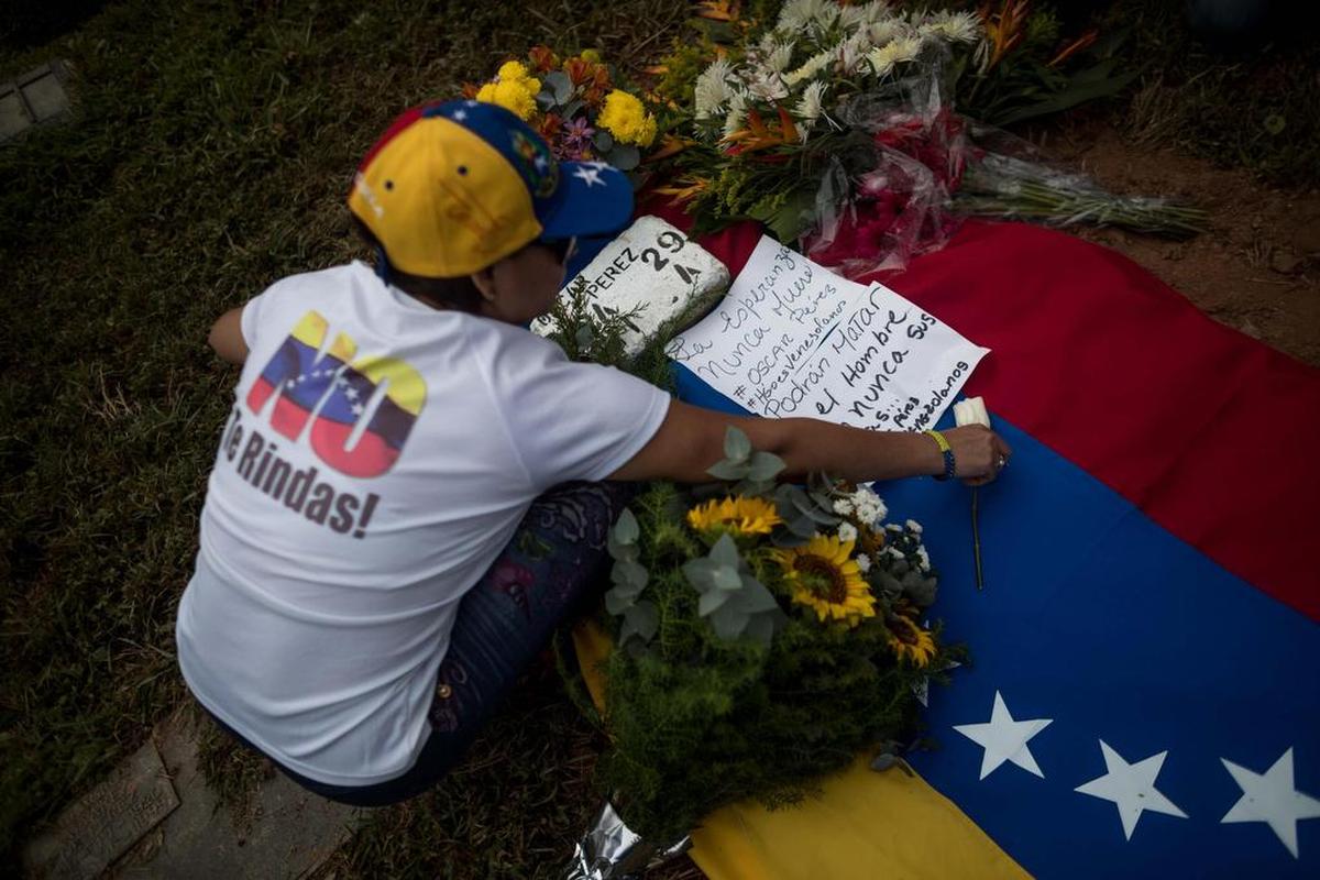 Una mujer deja un mensaje en una ofrenda floral en homenaje a Óscar Pérez el domingo 21 de enero de 2018, en el Cementerio del Este en Caracas (Venezuela).