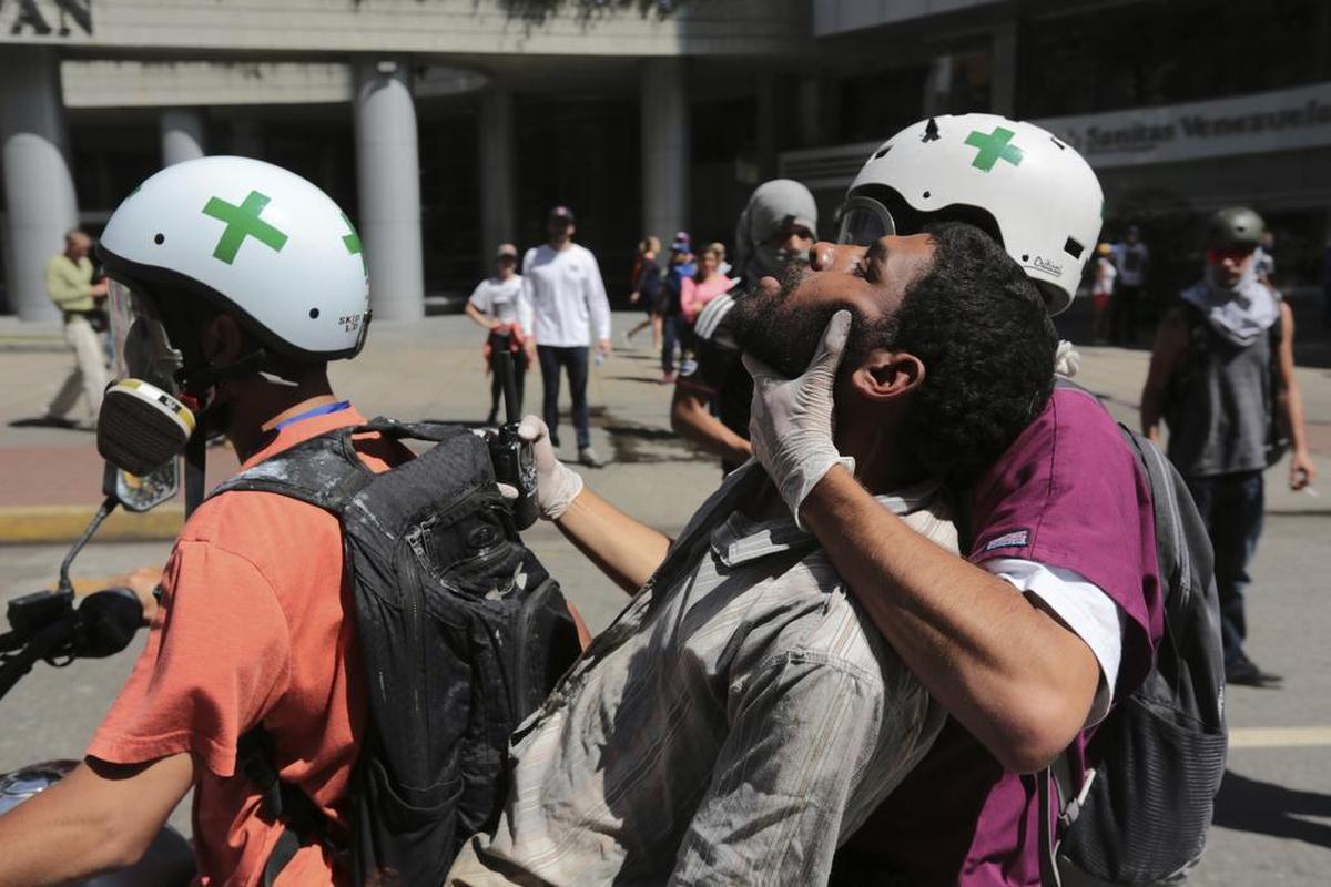 Un hombre es trasladado por voluntarios después de que fue afectado por gases lacrimógenos durante protestas antigubernamentales en Caracas, Venezuela.
