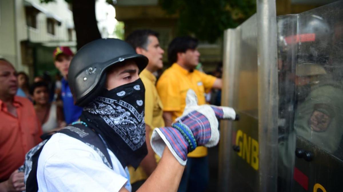 Manifestantes discuten con la policía antidisturbios durante una marcha en Caracas el 26 de abril de 2017.