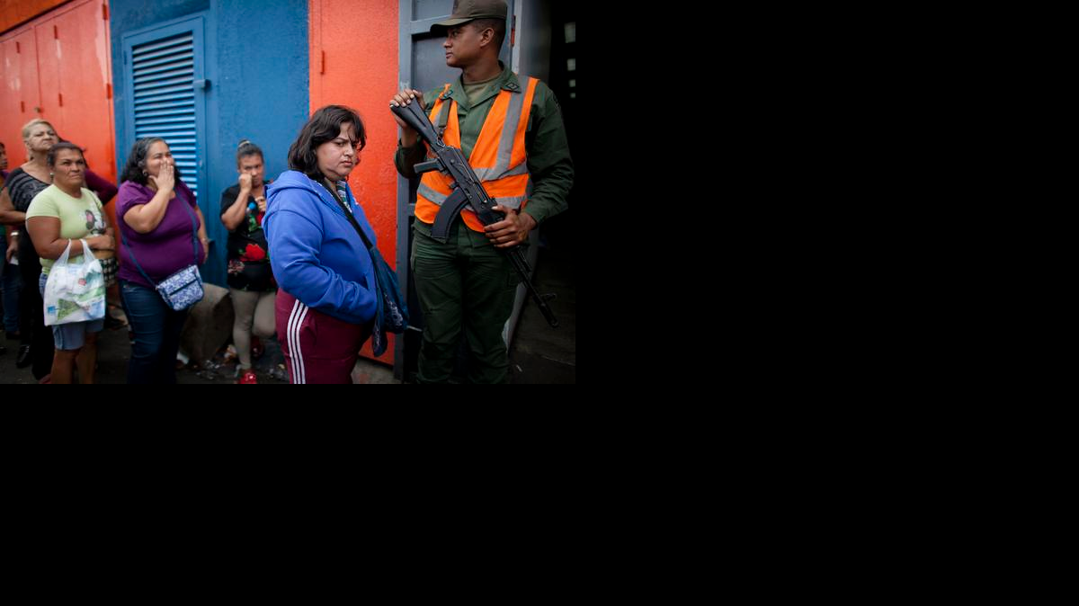 
Un guardia nacional vigila una fila en el supermercado Día a Día, el 3 de febrero en Caracas. 
