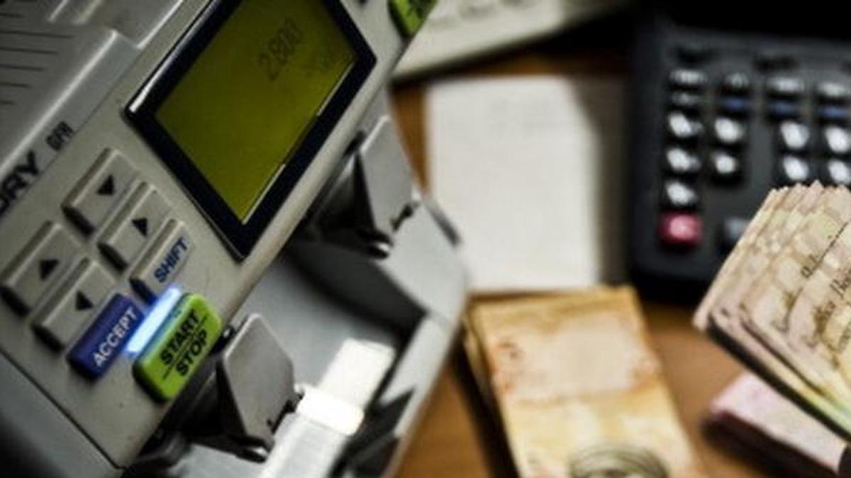 
El dueño de un restaurante en Caracas cuenta billetes de 100 bolívares en esta foto de archivo.
