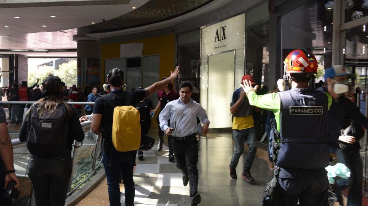 Un cliente corre en un centro comercial de Caracas después que la policía lanzó gases lacrimógenos a manifestantes opositores, el 6 de julio.