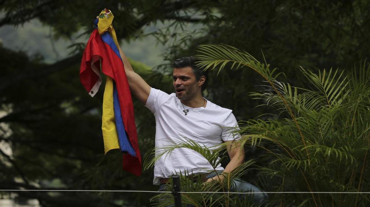 El líder de la oposición Leopoldo López sostiene una bandera nacional venezolana mientras saluda a sus seguidores fuera de su casa en Caracas, Venezuela, el sábado 8 de julio de 2017.