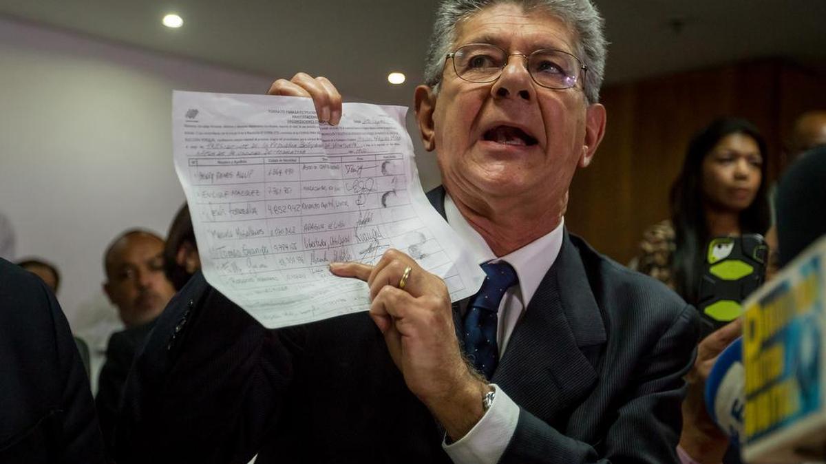 El presidente de la Asamblea Nacional de Venezuela, Henry Ramos Allup (c), muestra una copia de algunas firmas para solicitar el referendo revocatorio del presidente de Venezuela, Nicolás Mauduro, durante una conferencia de prensa el 31 de mayo del 2016, en Caracas (Venezuela).