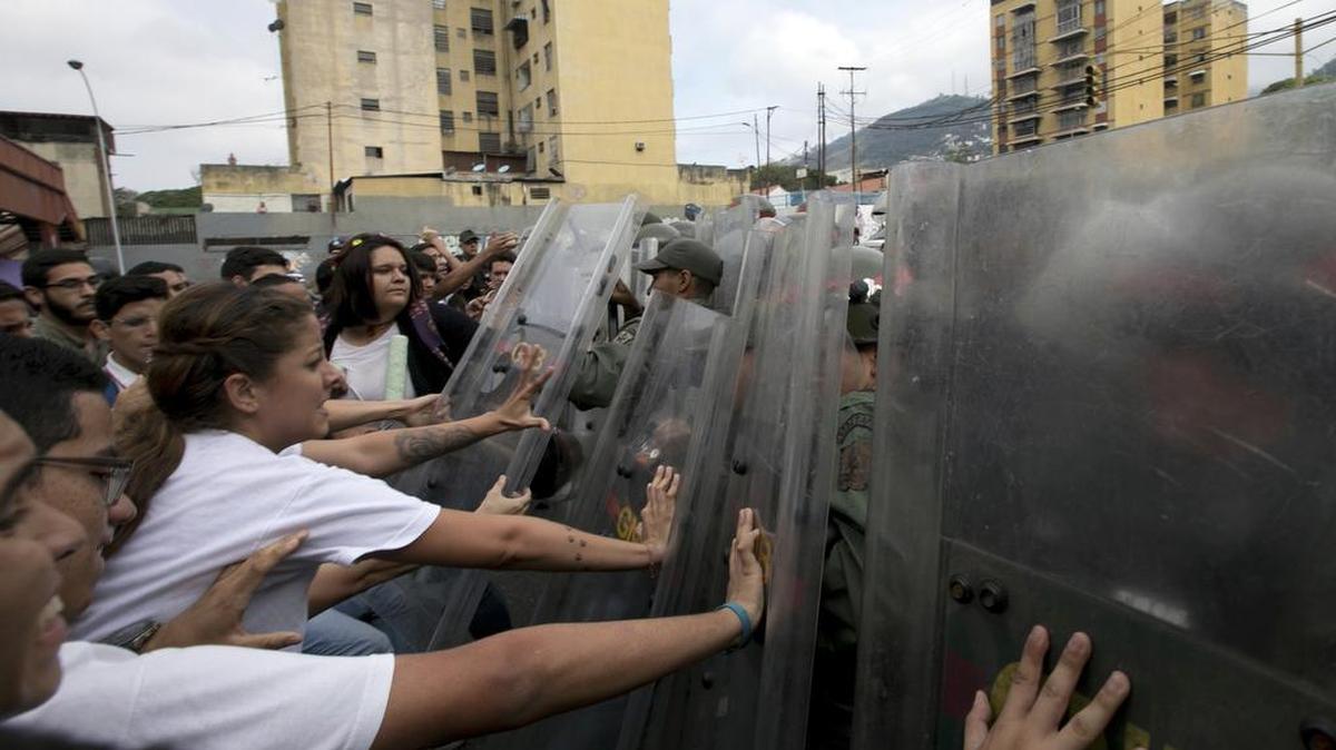 Estudiantes universitarios se enfrentan a soldados de la Guardia Nacional el viernes en Caracas, Venezuela.