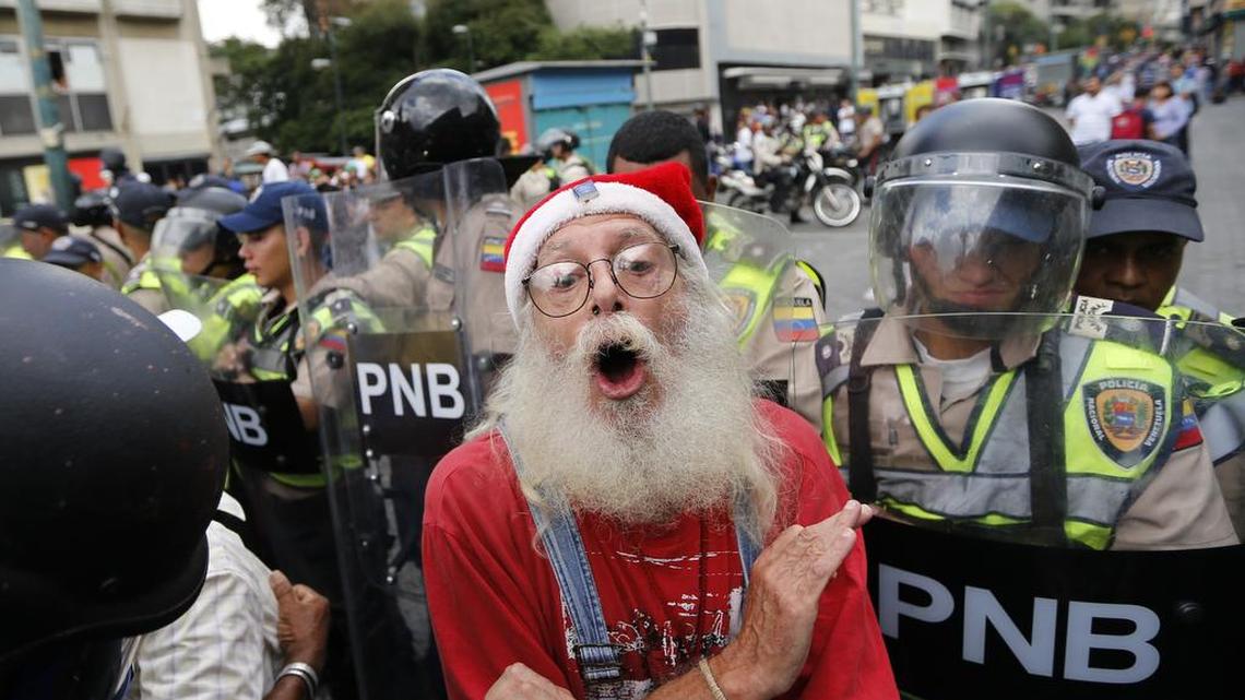 Un hombre se burla de la policía que bloquea una marcha de los venezolanos adultos mayores que buscan llegar a la Defensoría del Pueblo en protesta por el presidente Nicolás Maduro en Caracas, Venezuela, el viernes 12 de mayo de 2017.