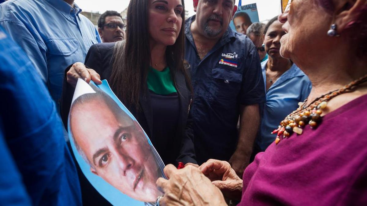Eveling Trejo (c), esposa del opositor Manuel Rosales, sostiene un afiche con la imagen de su esposo en las inmediaciones del Palacio de Justicia hoy, jueves 12 de noviembre del 2015, en Caracas (Venezuela).