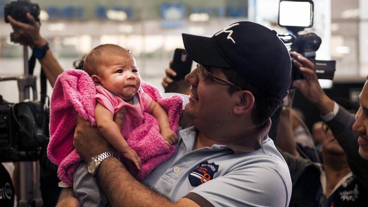 Fotografía cedida por la ONG Unión Venezolana en Perú, de un inmigrante venezolano radicado en Perú mientras sostiene a su hijo el jueves 23 de noviembre de 2017, en Lima (Perú).