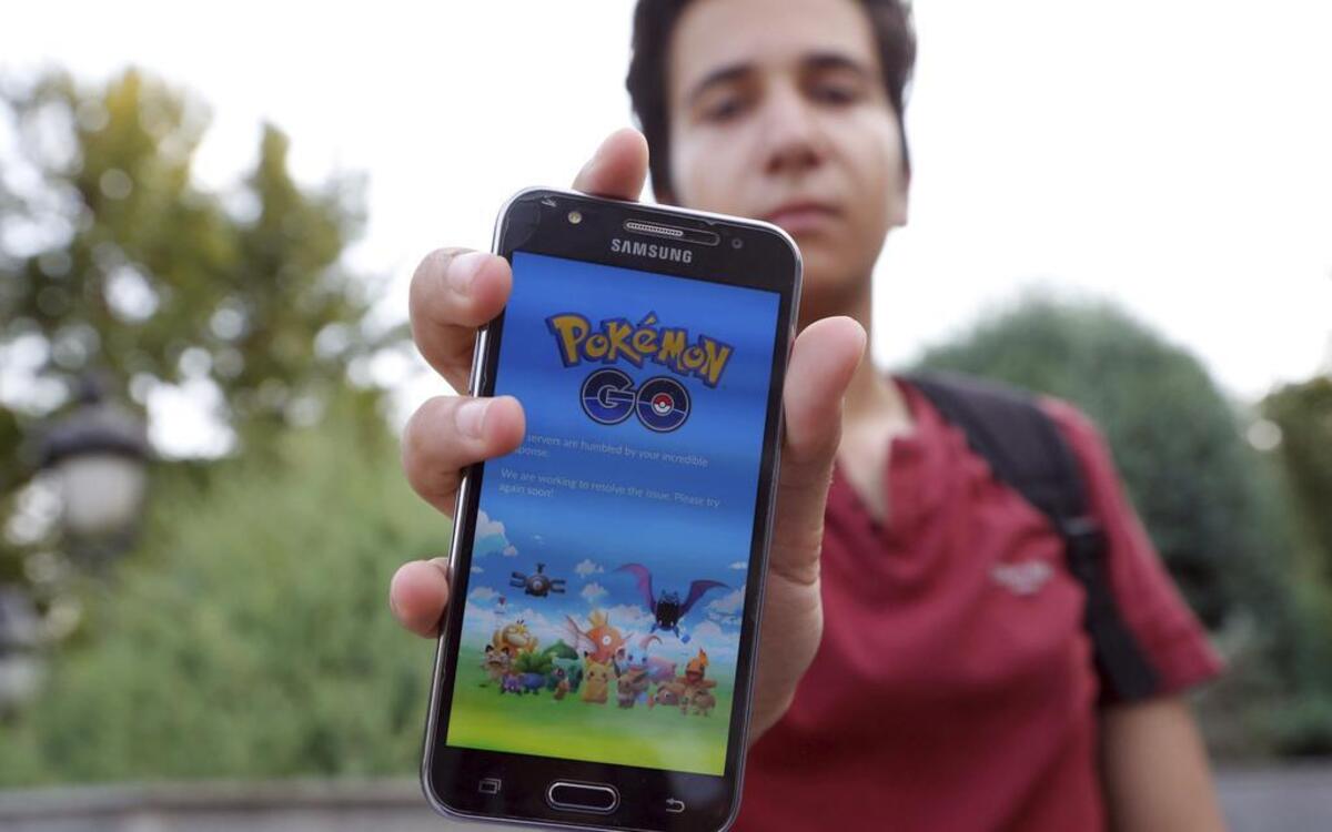 Un adolescente muestra la pantalla de su teléfono móvil donde aparece el texto que dice que la aplicación de "Pokémon GO" no puede conectarse en el parque Mellat de Teherán, Irán, el 12 de agosto de 2016.