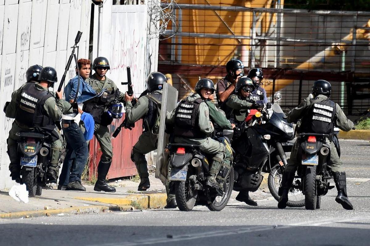 Miembros de la Guardia Nacional Bolivariana arrestan a un manifestante opositor el lunes en Caracas, Venezuela.