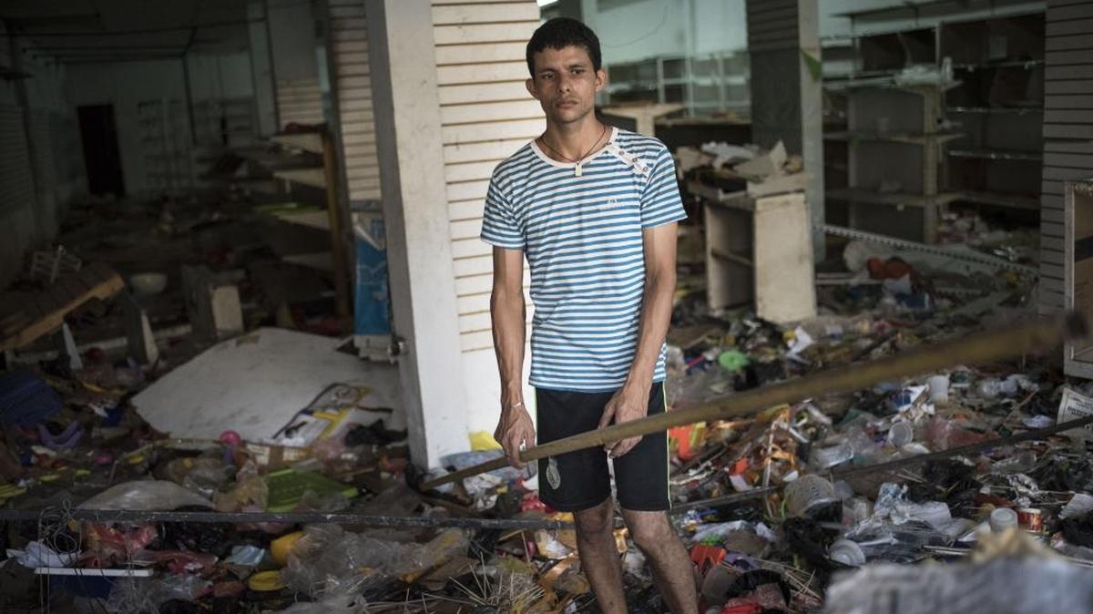 Un empleado observa los destrozos en una tienda en La Fría en Táchira, el 19 de diciembre. Los saqueos de comercios aumentaron la tensión en que vive Venezuela.