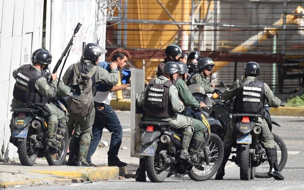 Miembros de la Guardia Nacional Bolivariana retienen a un manifestante opositor en una calle de Caracas, Venezuela, el lunes 26 de junio de 2017.